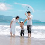 A joyful family enjoying a sunny day at Da Nang Beach, Vietnam, showcasing a heartwarming moment.
